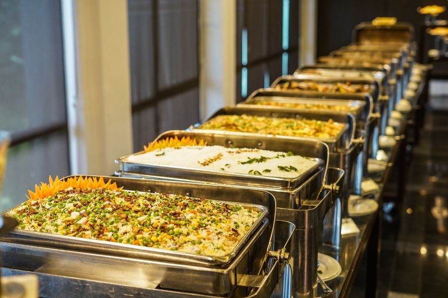 A table filled with buffet trays full of food.